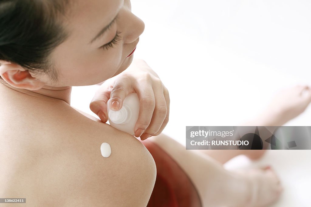 Woman applying body cream
