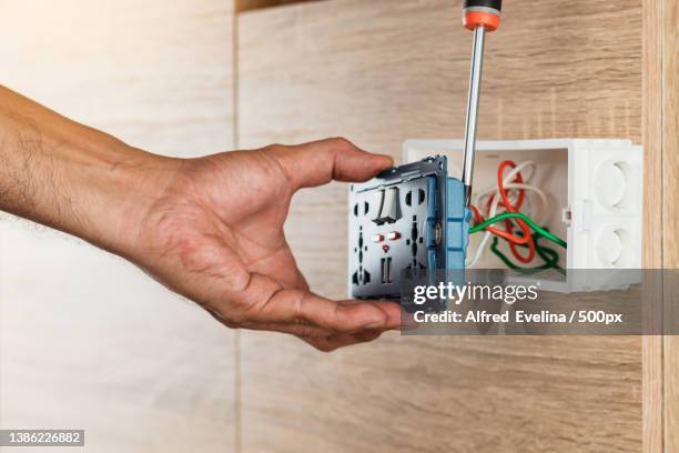 hand of an electrician is using a screwdriver - electric shock stockfoto's en -beelden