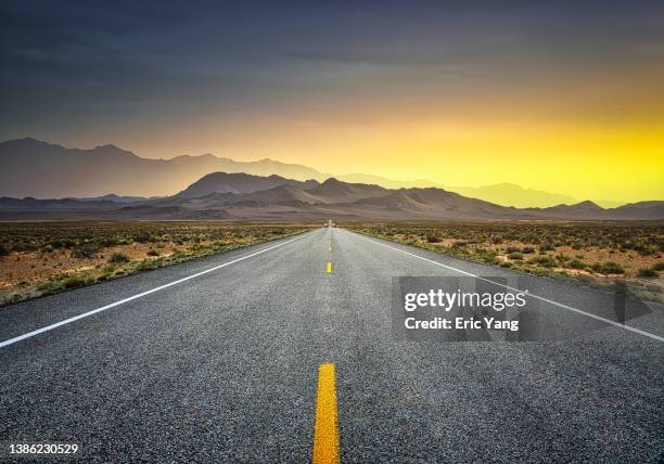 straight road to the mountain - dirt road landscape sunset stock-fotos und bilder