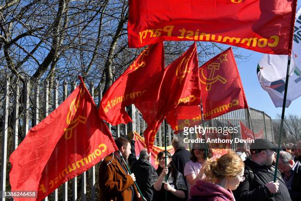 Communist Party flags are held by demonstrators as they gather outside the entrance to the Port of Liverpool on March 18, 2022 in Liverpool, England....