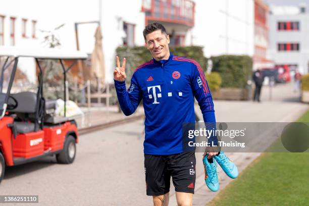 Robert Lewandowski of FC Bayern Muenchen shows a peace sign during a training session at Saebener Strasse training ground on March 18, 2022 in...