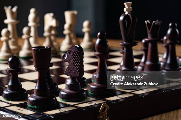 chess, game and competition. he placed pawns on a black-and-white game board. the beginning of the game. the concept of thinking, leadership and strategy in business. intellectual leisure, corporate entertainment. - chess board businessman stock-fotos und bilder
