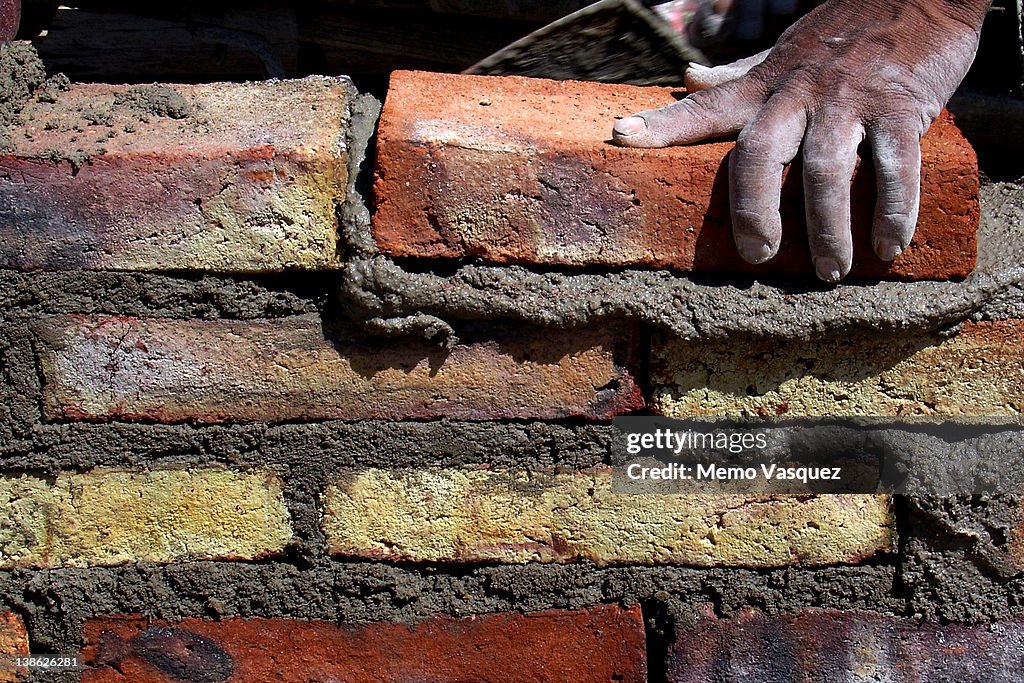 Human hand building brick wall