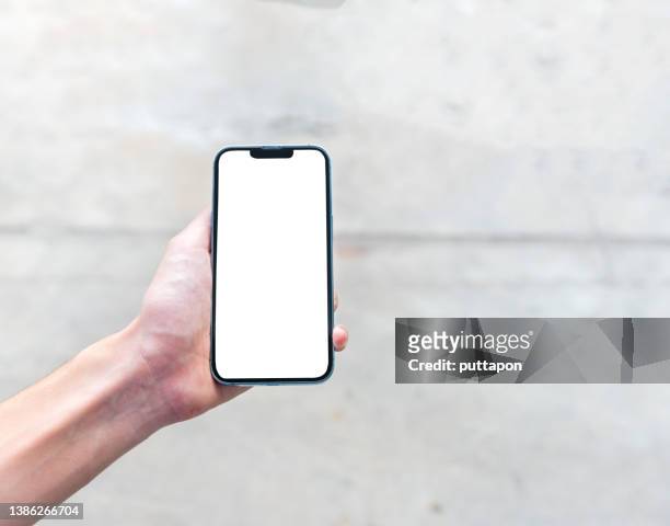 close up of woman hand holding smartphone on white background, cropped hand using smartphone on the background white, concept of using technology in daily life - smartphone mockup stock-fotos und bilder