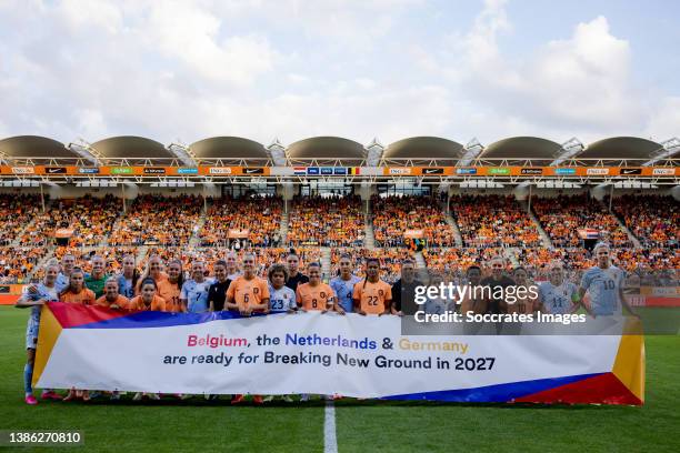 Players of Holland Women and Belgium Women posing with a banner for the World Cup bid 2027 during the International Friendly Women match between...