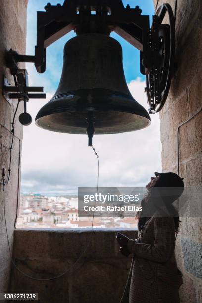 woman looking at the bell inside the bell tower - 鐘樓 塔 個照片及圖片檔