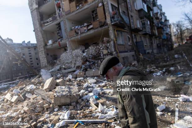 Man walks amid debris in front of a residential apartment complex that was heavily damaged by a Russian attack on March 18, 2022 in Kyiv, Ukraine....
