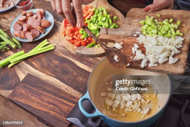 zubereitung cajun stil huhn, garnelen und wurst jambalaya in einem gusseisen topf - kreolische kultur stock-fotos und bilder