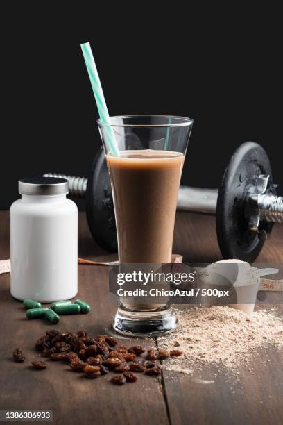 side view of protein shake vitamins and black dumbbells on white background - glutamina imagens e fotografias de stock