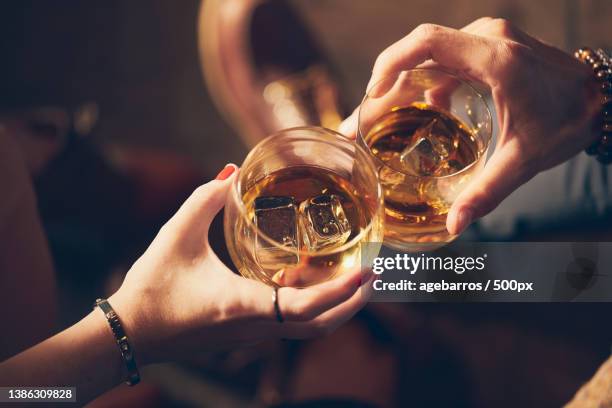 cropped hands of friends toasting drinks in glass - bourbon whisky stockfoto's en -beelden