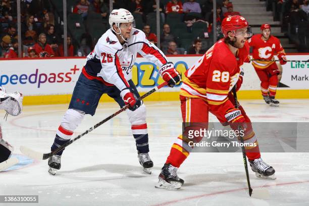 Elias Lindholm of the Calgary Flames battles against Nic Dowd of the Washington Capitals at Scotiabank Saddledome on March 8, 2022 in Calgary,...