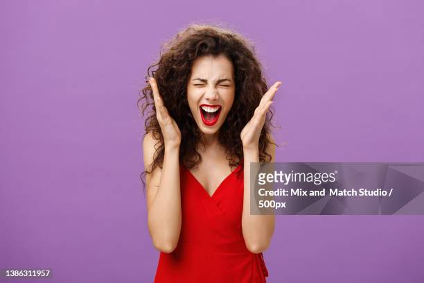 woman going crazy screaming being tensed under pressure closing eyes - purple dress stockfoto's en -beelden