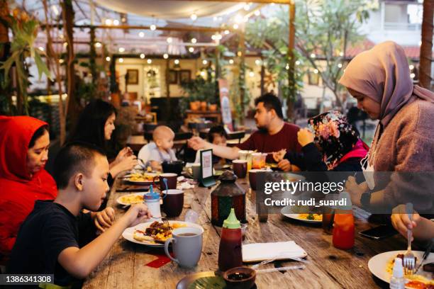 family eating iftar and enjoying breaking of fasting - indonesia family imagens e fotografias de stock