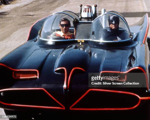 Burt Ward, US actor, and Adam West, US actor, both in costume as the 'Dynamic Duo' riding in the Batmobile in a publicity still issued for the...
