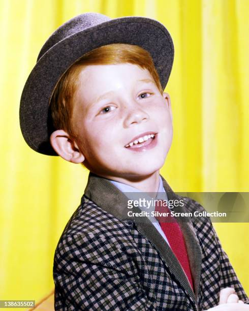 Ron Howard, US actor and director, wearing a grey hat and checked jacket, with a blue shirt and a red tie, in a studio portrait issued as publicity...