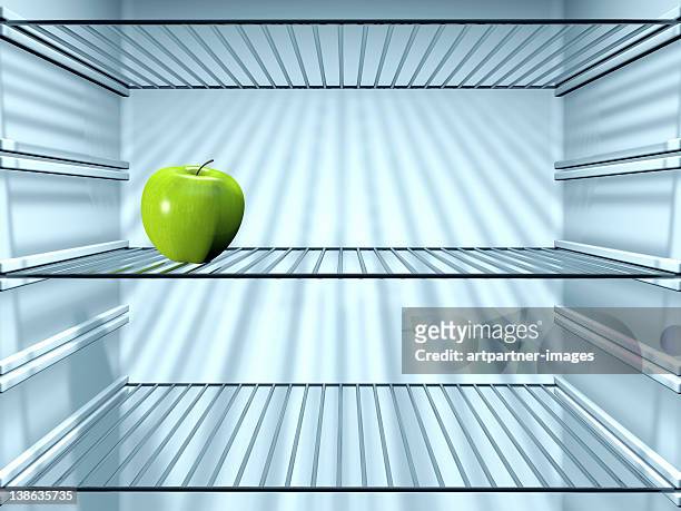 fresh green apple in an empty fridge - sparse fridge stock pictures, royalty-free photos & images