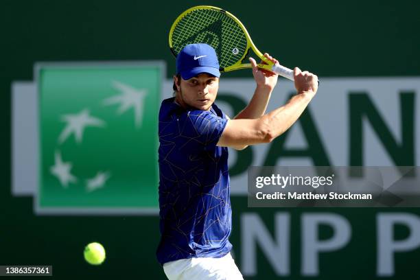 Miomir Kecmanovic of Serbia returns a shot to Taylor Fritz during the quarterfinals of the BNP Paribas Open at the Indian Wells Tennis Garden on...