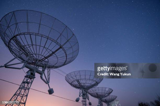 radio telescope under the stars at night - science et technologie stock-fotos und bilder