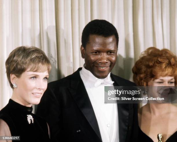 Julie Andrews, British actress, wearing black outfit with a brooch at the neck, Sidney Poitier, Bahamian American actor, wearing a black tuxedo,...