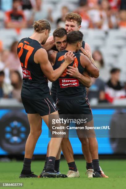 Stephen Coniglio of the Giants celebrates kicking a goal with team mates during the round one AFL match between the Greater Western Sydney Giants and...