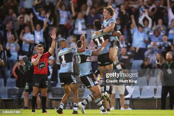 Nicholas Hynes of the Sharks celebrates with team mates after kicking a conversion to win the match after the final siren during the round two NRL...