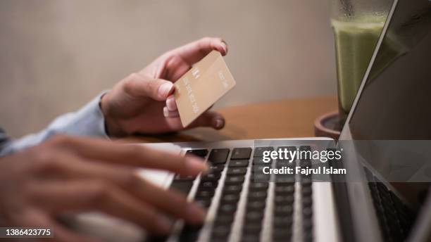 paying with credit card online with laptop - charging stockfoto's en -beelden