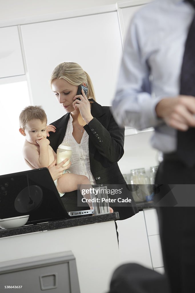 Mother trying to work while holding baby