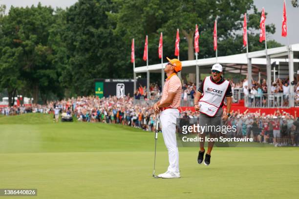 Golfer Rickie Fowler and his caddy Ricky Romano react after Fowler makes the winning birdie putt on the 18th hole during a playoff on July 2 during...