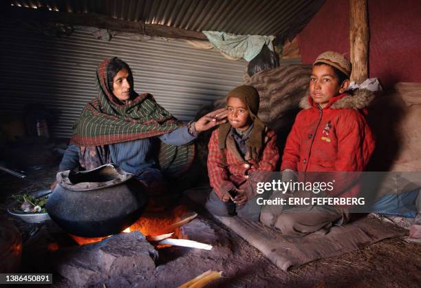 Pakistani family sits in their corrugated iron shelter in Shamlai, in Pakistan's North West Frontier Province, 10 January 2006, on the eve of the...