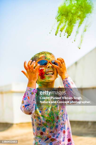 a toddler enjoying the color blast of holi festival - body paint imagens e fotografias de stock