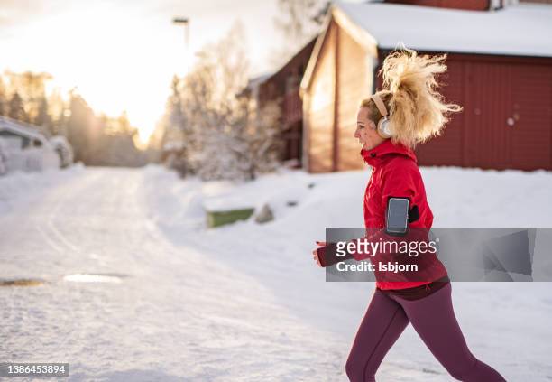 woman running during snowy day - oslo city life stock pictures, royalty-free photos & images