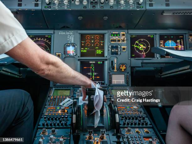 flight deck interior and control part of the aircraft cockpit. pilots conducting pre flight departure checks and paperwork whilst refuelling and boarding of passengers before flight - airbus cockpit stock pictures, royalty-free photos & images