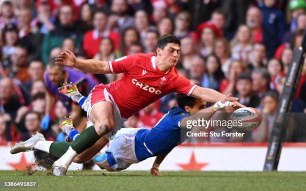 Louis Rees-Zammit of Wales contest for the ball with Ange Capuozzo of Italy during the Six Nations Rugby match between Wales and Italy at...