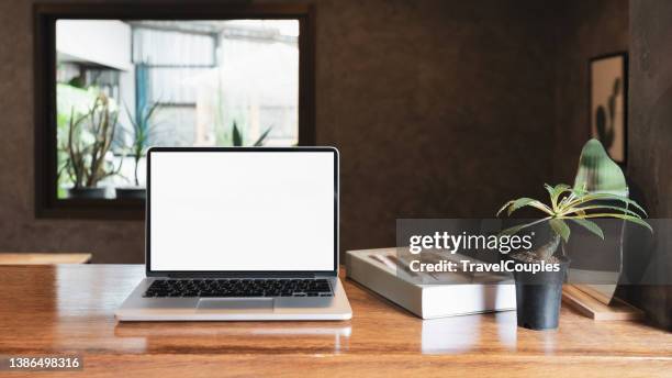 laptop computer blank screen on table in cafe background. laptop with blank screen on table of coffee shop blur background - office front desk stock-fotos und bilder