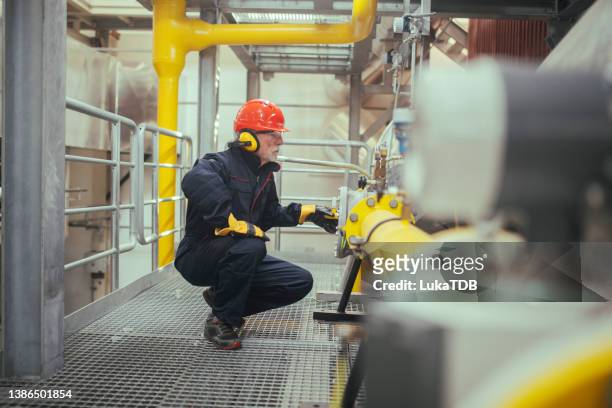 trabajador industrial que trabaja en planta industrial. - planta petroquímica fotografías e imágenes de stock