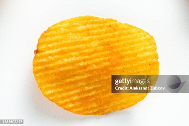 crispy fried potato chips are scattered on a white background or table. corn spicy fatty chips with paprika and spices. the concept of unhealthy diet and lifestyle, accumulation of excess weight. copy space. background of food. - grooved stock pictures, royalty-free photos & images