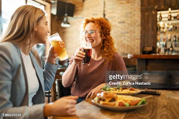 freundinnen beim bier - fastfood restaurant table stock-fotos und bilder
