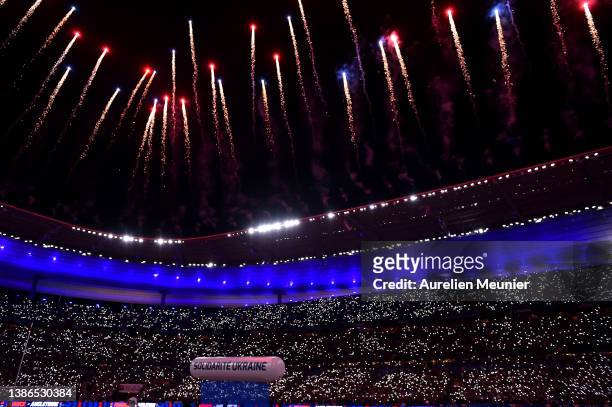 An inflatable banner which says Solidarite Ukraine, to indicate peace and sympathy with Ukraine, is seen as Fireworks go off over the the Stade de...