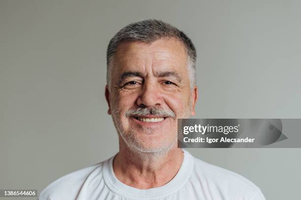 porträt von ein älterer mann schaut an die kamera - hispanic senior face stock-fotos und bilder