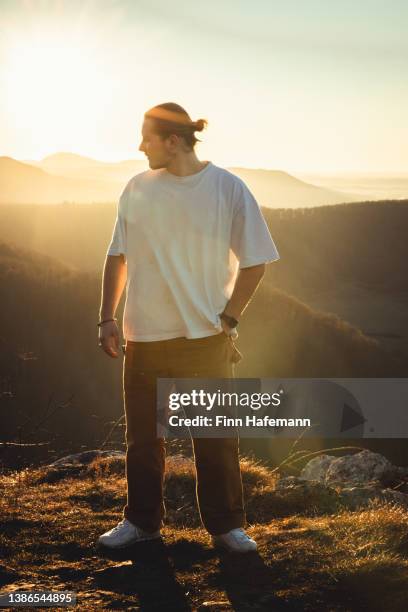 pensive lonely young man looking towards sunset from mountain top - mount disappointment stock pictures, royalty-free photos & images