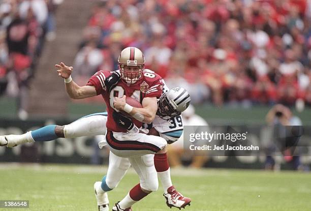 Tight end Brent Jones of the San Francisco 49ers tries to break away from defensive back Brett Maxie of the Carolina Panthers at 3Com Park in San...