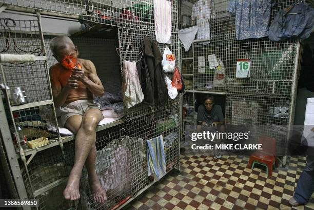 Hongkong-handover-10years-economy This picture taken 14 May, 2007 shows 78-year-old Tai Yum-po smoking a cigarette while on his bed in a "cage...