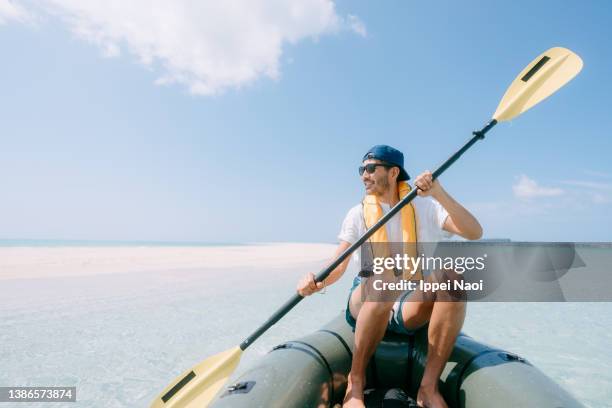 man sea kayaking on tropical water with sandbar, okinawa, japan - alleen oudere mannen stockfoto's en -beelden