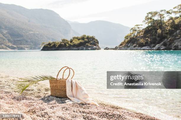 straw beach bag on sandy beach. - straw stock photos et images de collection