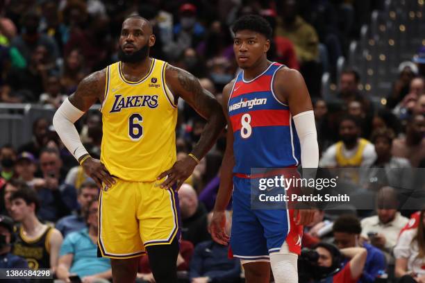 LeBron James of the Los Angeles Lakers looks on next to Rui Hachimura of the Washington Wizards during the first half at Capital One Arena on March...