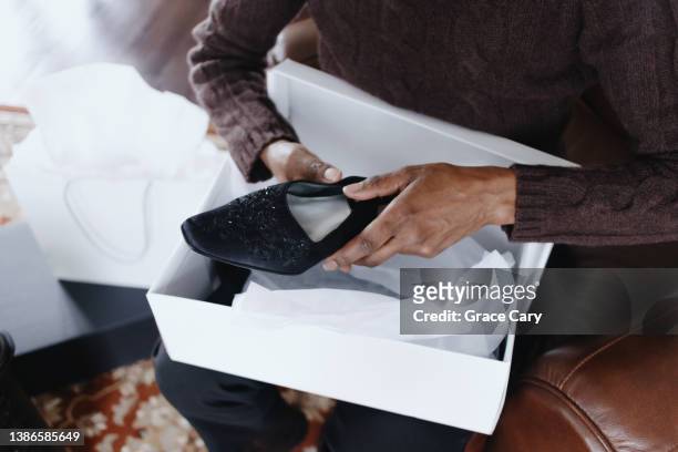 woman removes new dress shoes from box - schuhkarton stock-fotos und bilder