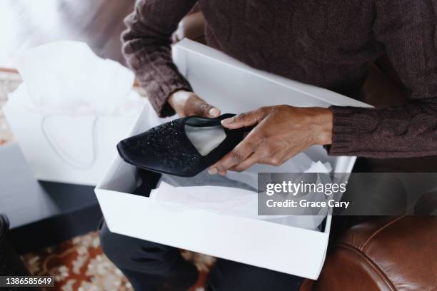 woman removes new dress shoes from box - shoe box stock pictures, royalty-free photos & images