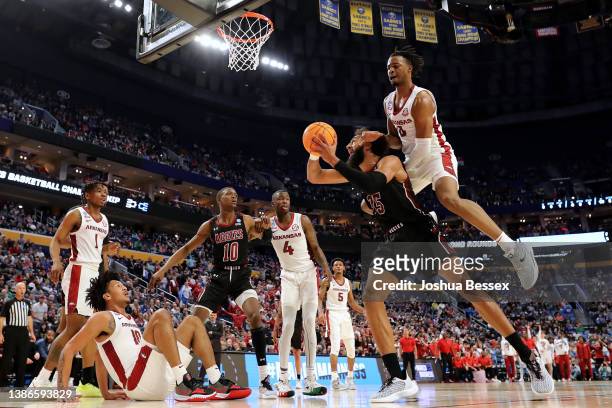 Johnny McCants of the New Mexico State Aggies shoots the ball against Stanley Umude of the Arkansas Razorbacks during the second half while...