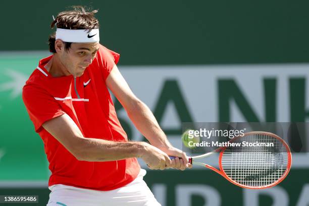 Taylor Fritz returns a shot to Andrey Rublev of Russia during the semifinals of the BNP Paribas Open at the Indian Wells Tennis Garden on March 19,...