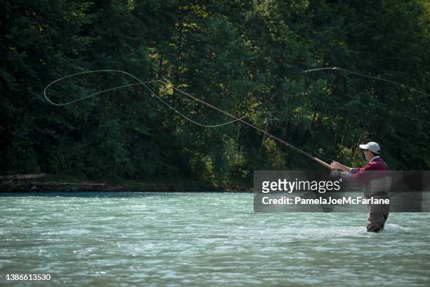 pesca a mosca dell'uomo asiatico maturo a river, british columbia, canada - lenza foto e immagini stock